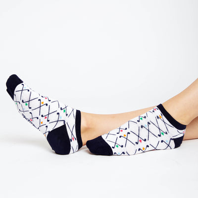 woman wears white socks with pattern of navy crossed golf clubs and rainbow hearts