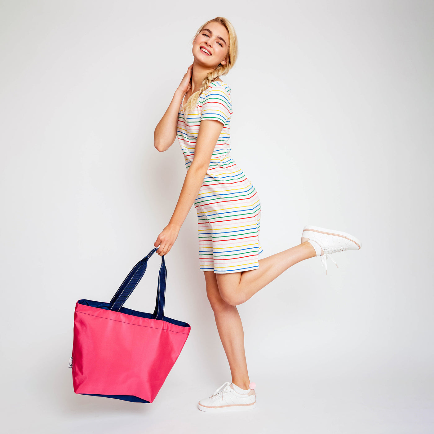 woman holding pink nylon tote bag with navy straps