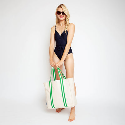 woman holding natural canvas tote with lime green and white cotton webbing straps