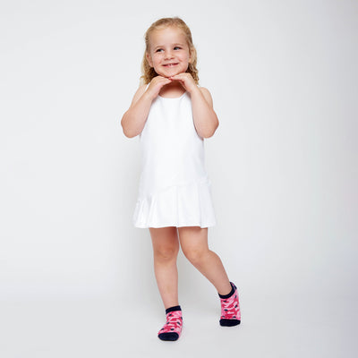 little girl wearing pair of hot pink camo kids socks with navy heel and toes, and navy tennis balls stitched on socks