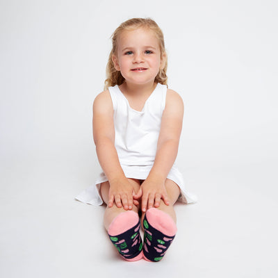 girl wearing pair of navy kids socks with pink heel and toes with heart and tennis ball pattern stitched on sock