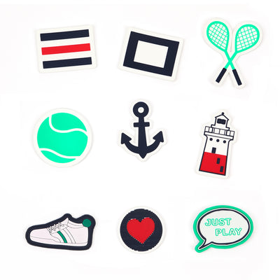 Flat view of patches for backpack, included flag patches, crossed racquets, tennis ball, anchor, lighthouse, sneaker, heart and speech bubble that says just play. 