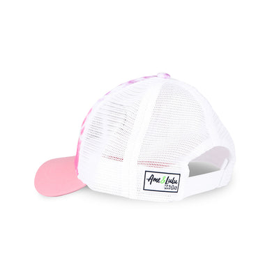 Side view of pink purple and white tie dye kids trucker hat with purple smiling tennis ball embroidered on front