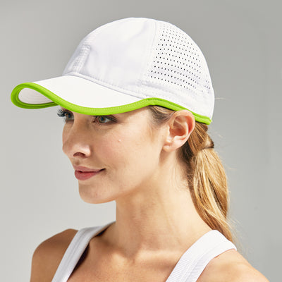 woman wears white sport hat with lime green trim.