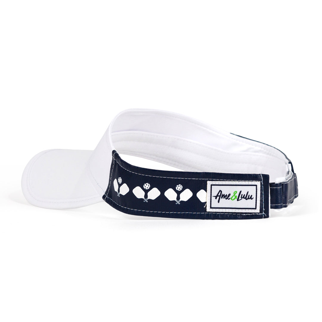 white visor with navy sides that have a repeat white crossed paddle pattern