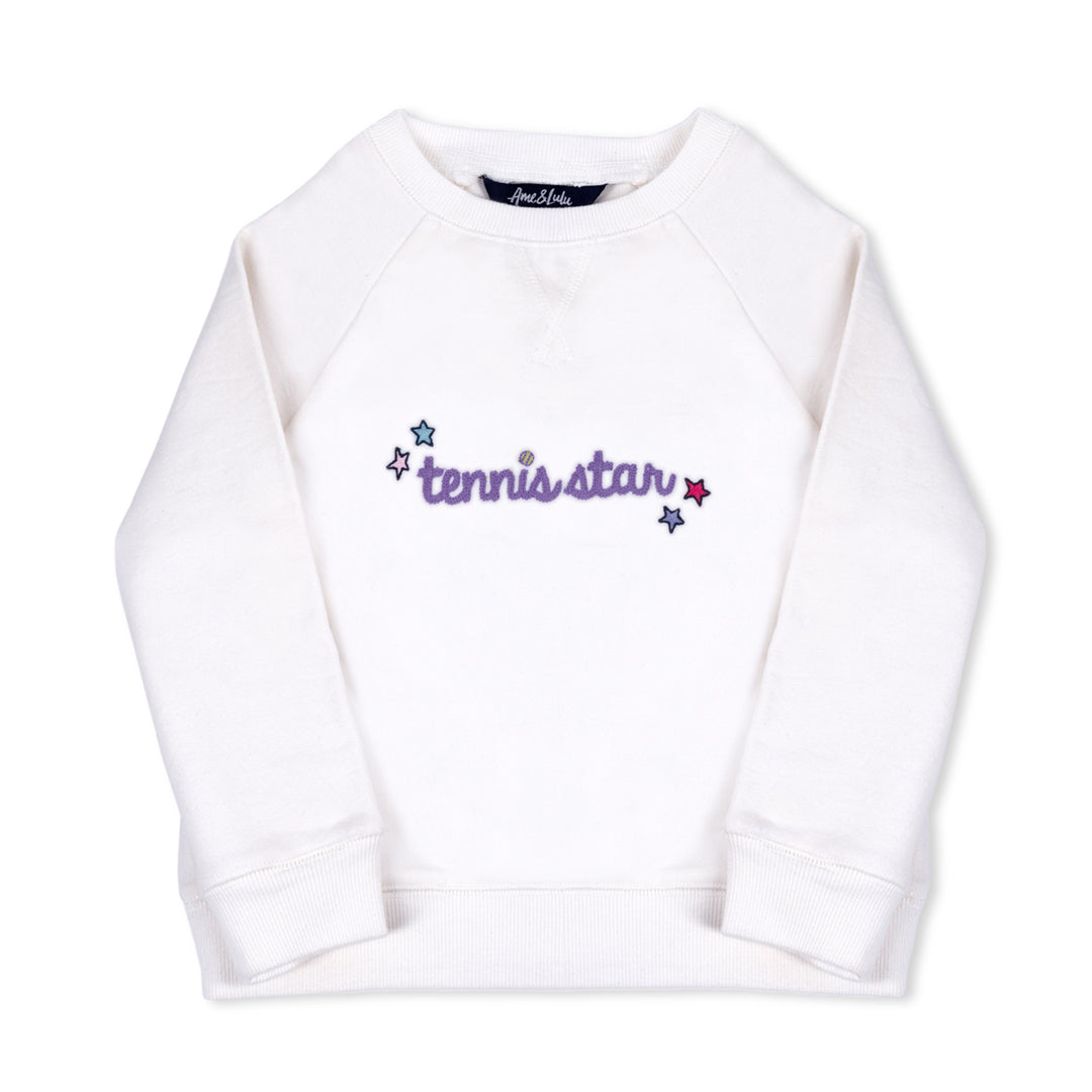 flat laying white kids sweatshirt with the word tennis star embroidered in purple cursive font on front 