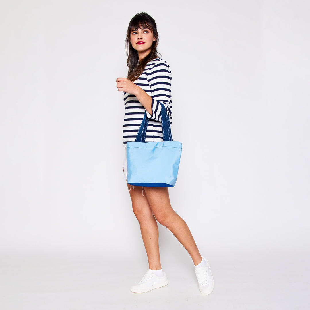 view of light blue mini surfside tote with navy straps