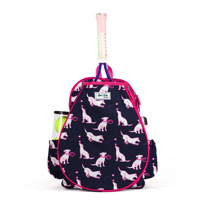 Front view of navy kids tennis backpack with hot pink trim and pattern of white puppies holding tennis racquets and tennis balls