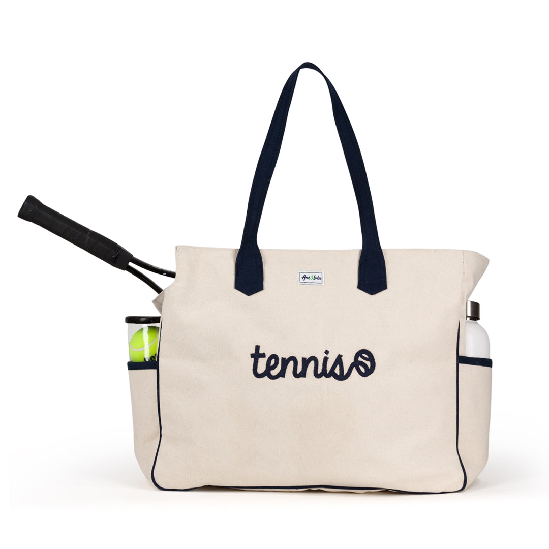 Front view of canvas tennis racquet tote bag with tennis racquet in bag. Front of the tote has embroidery that reads tennis in cursive font.