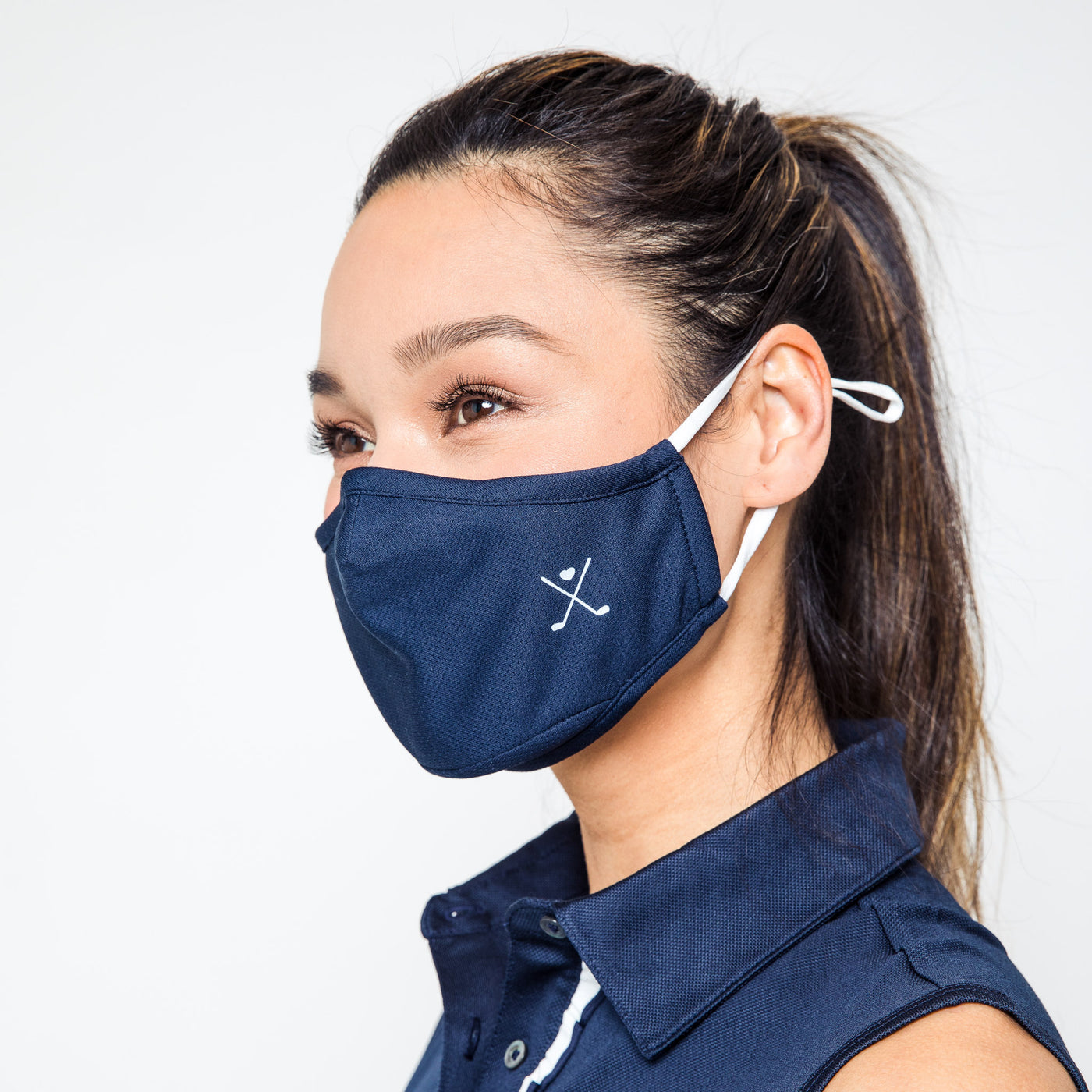 woman wearing navy face mask with white crossed golf clubs printed on one side