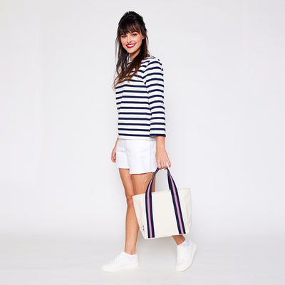 woman holding mini natural canvas tote with pink and navy cotton webbing straps
