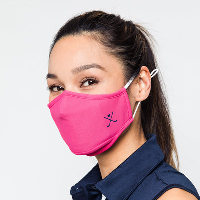 woman wearing hot pink face mask with navy crossed golf club printed on one side