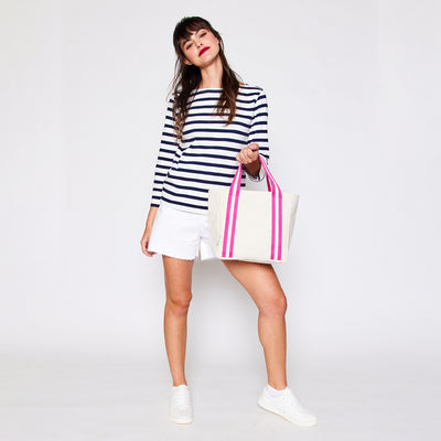 woman holding mini natural canvas tote with hot pink and white cotton webbing straps