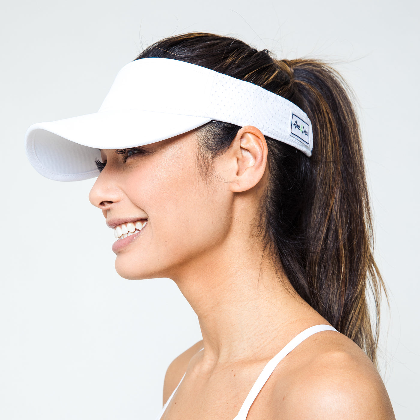 Woman wears white performance visor