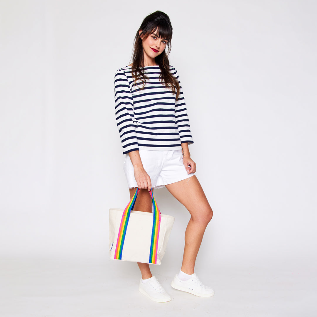 woman holding mini natural canvas tote with rainbow striped cotton webbing straps
