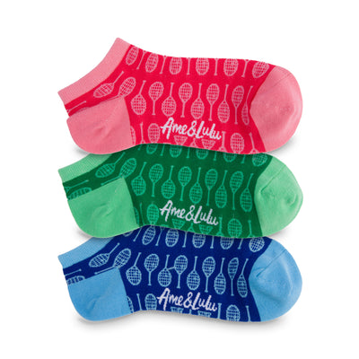 three pack of tennis socks lined up. One pink sock with light pink tennis racquets, green sock with light green tennis racquets and blue sock with light blue tennis racquets