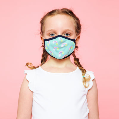 girl wearing light blue with pastel rainbow pattern kids face mask